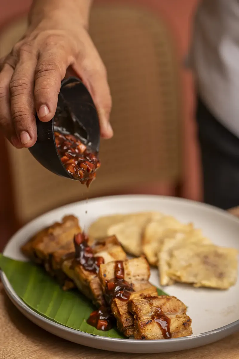 Sirviendo salsa sobre chicharrón de guayaba